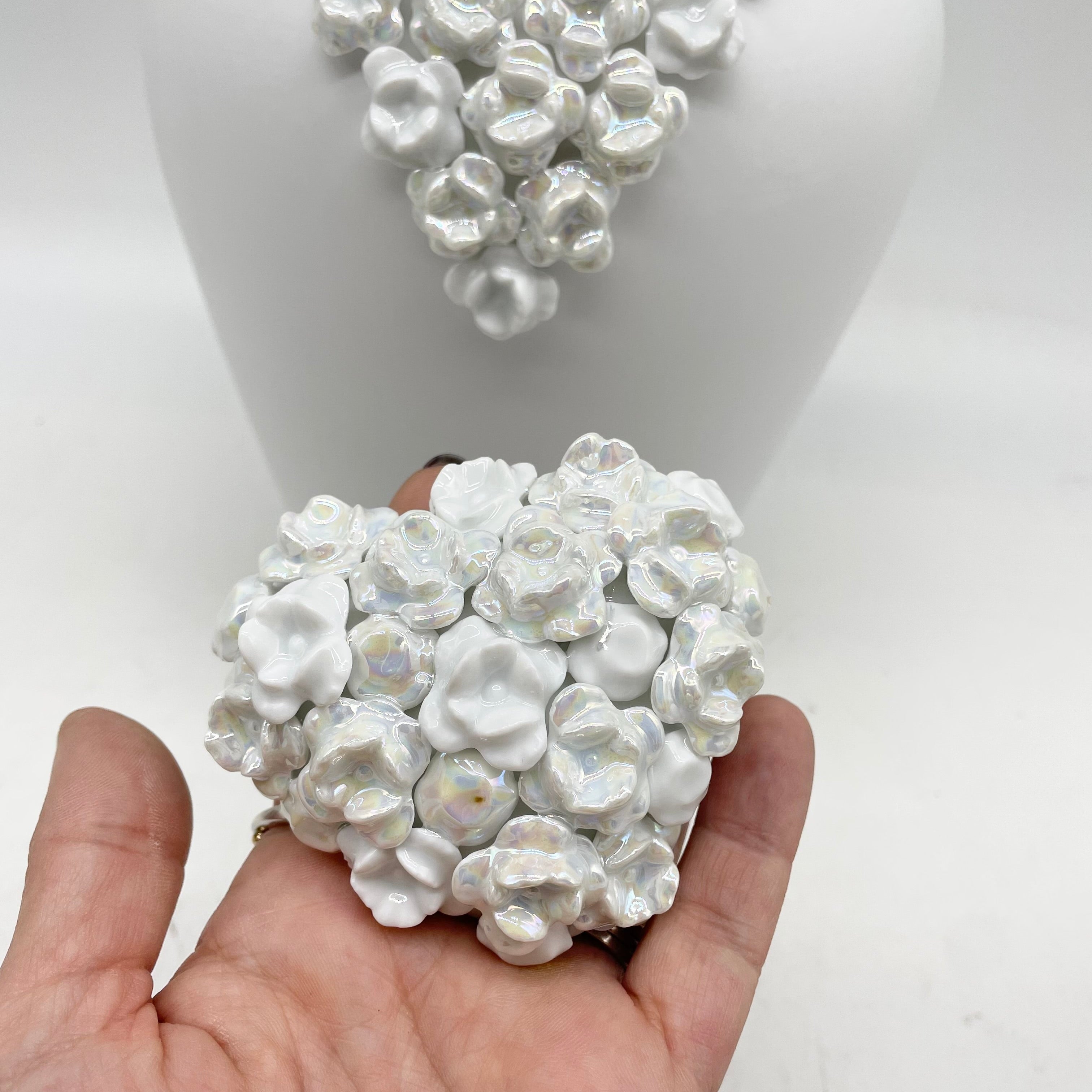 objet de décoration en forme de coeur symbole de l'amour. il y a en relief des petites fleurs qui on été posé à la main une par une au colage. création artisanale