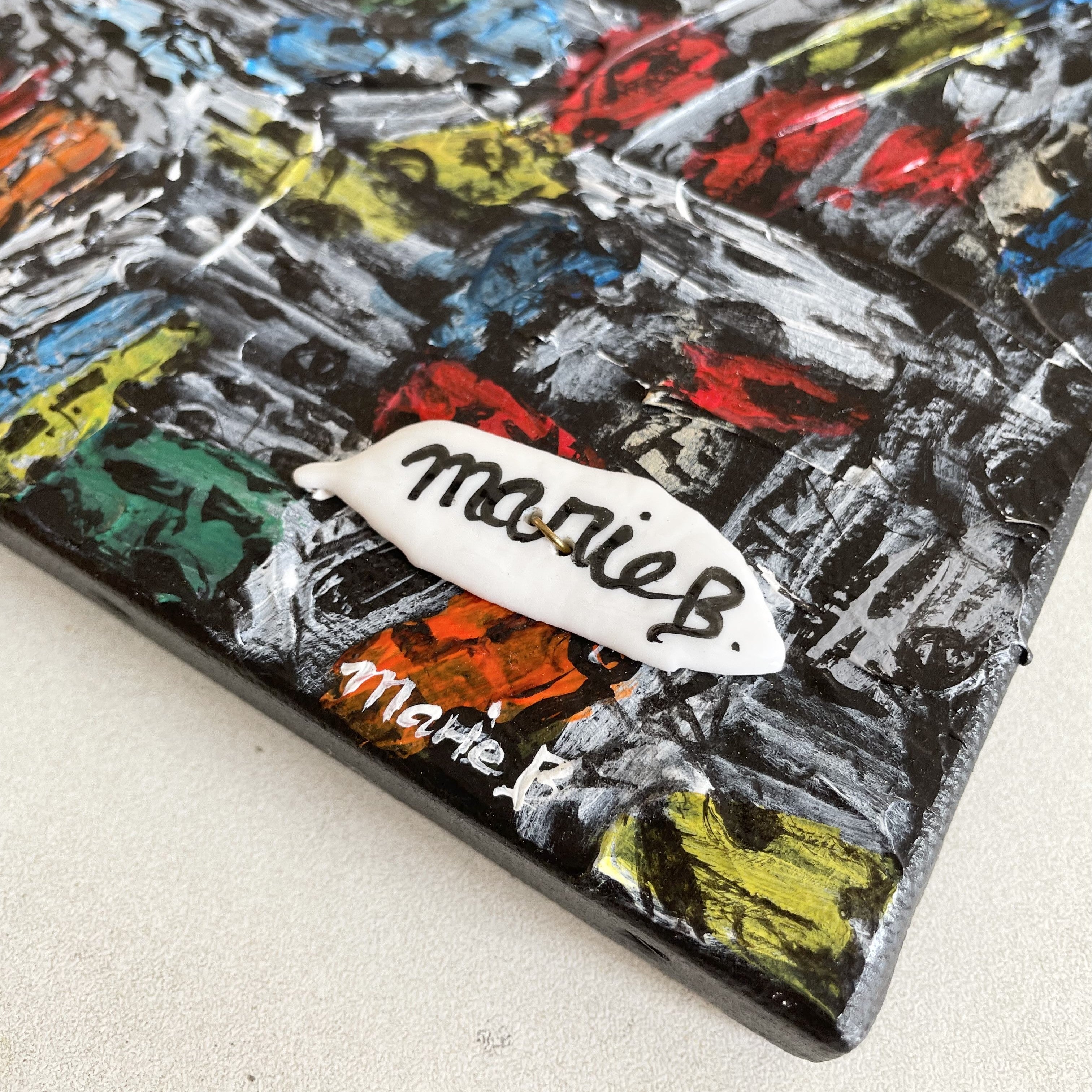 tableau acrylique et éléments en porcelaine. toile représente une casse automobiles. les couleurs sont jaune, bleu, rouge, orange, vert, noir et blanc. format paysage dimensions : 40x20