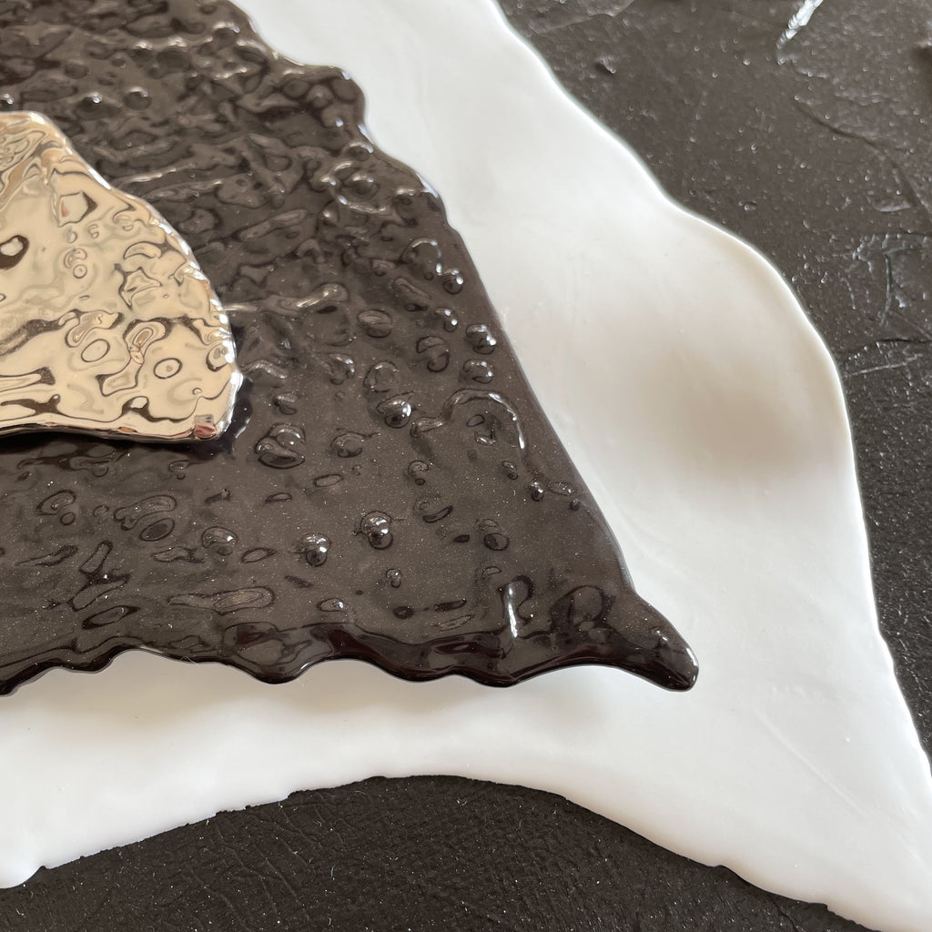 tableau acrylique et éléments en porcelaine. toile représente le coeur de vho . les couleurs sont noir, blanc et platine format paysage dimensions : 50x40